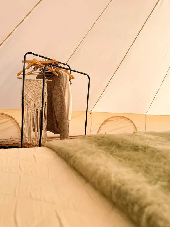 A soft, cosy bed and macramé corner inside the tent
