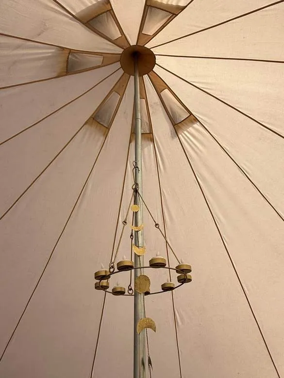 A moon-phase candle holder hanging from the centre pole