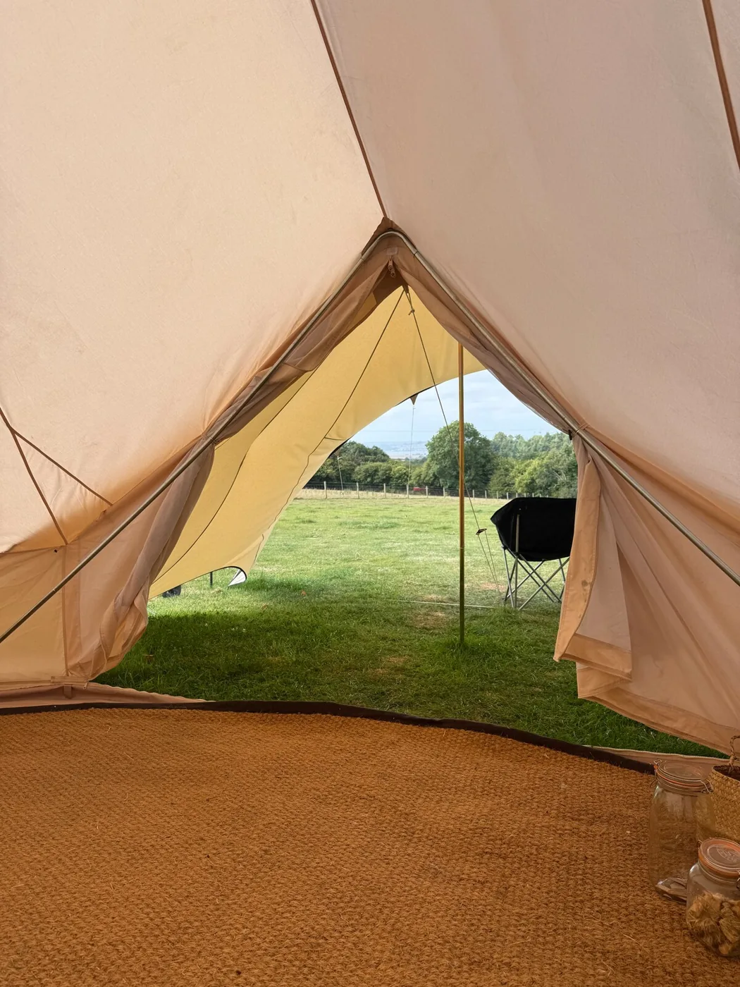 The open doorway of the Family Tent framing the field and chairs outside