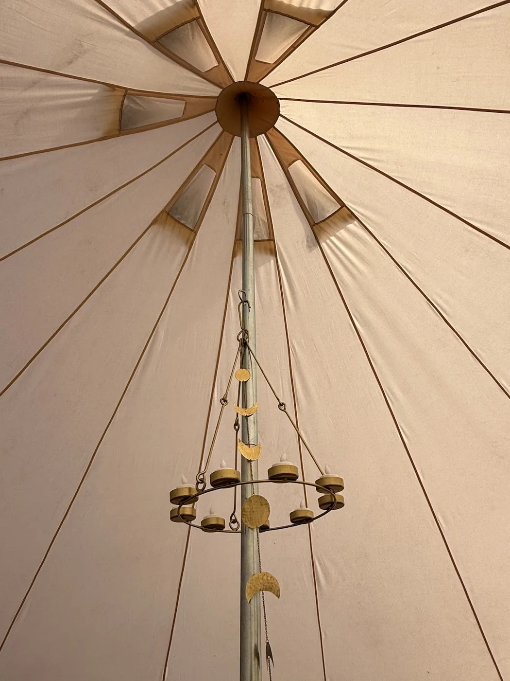 Looking up to the crown of the bell tent and its hanging candle holder